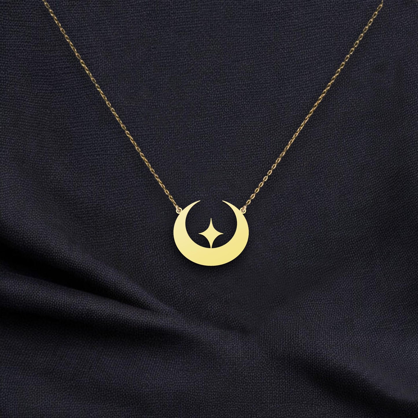 May include: Gold crescent moon necklace with a star cutout. The delicate gold chain and pendant feature a simple, modern design. This celestial-themed necklace is perfect for adding a touch of elegance to any outfit. The pendant is a smooth, polished gold with a subtle shine.