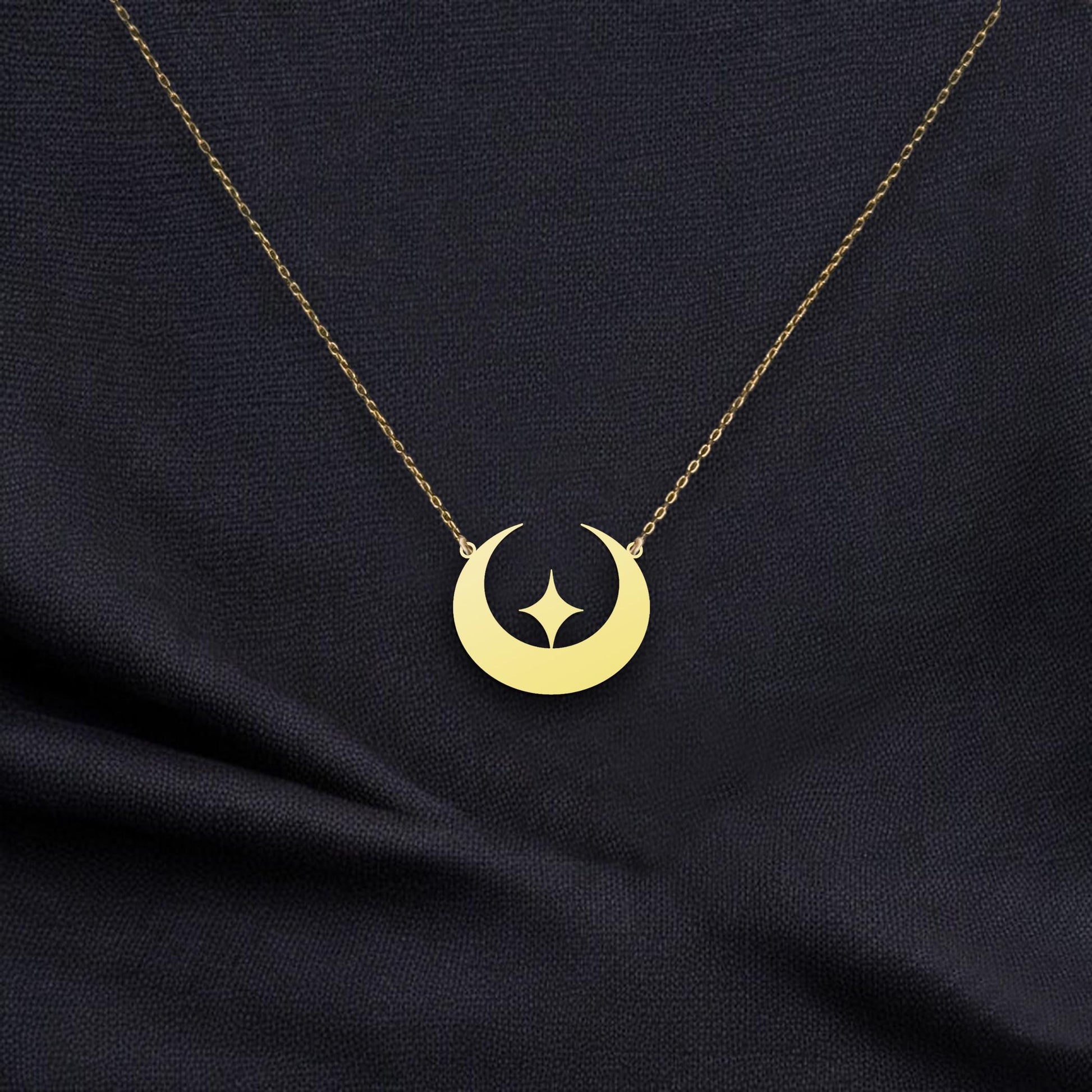 May include: Gold crescent moon necklace with a star cutout. The delicate gold chain and pendant feature a simple, modern design. This celestial-themed necklace is perfect for adding a touch of elegance to any outfit. The pendant is a smooth, polished gold with a subtle shine.