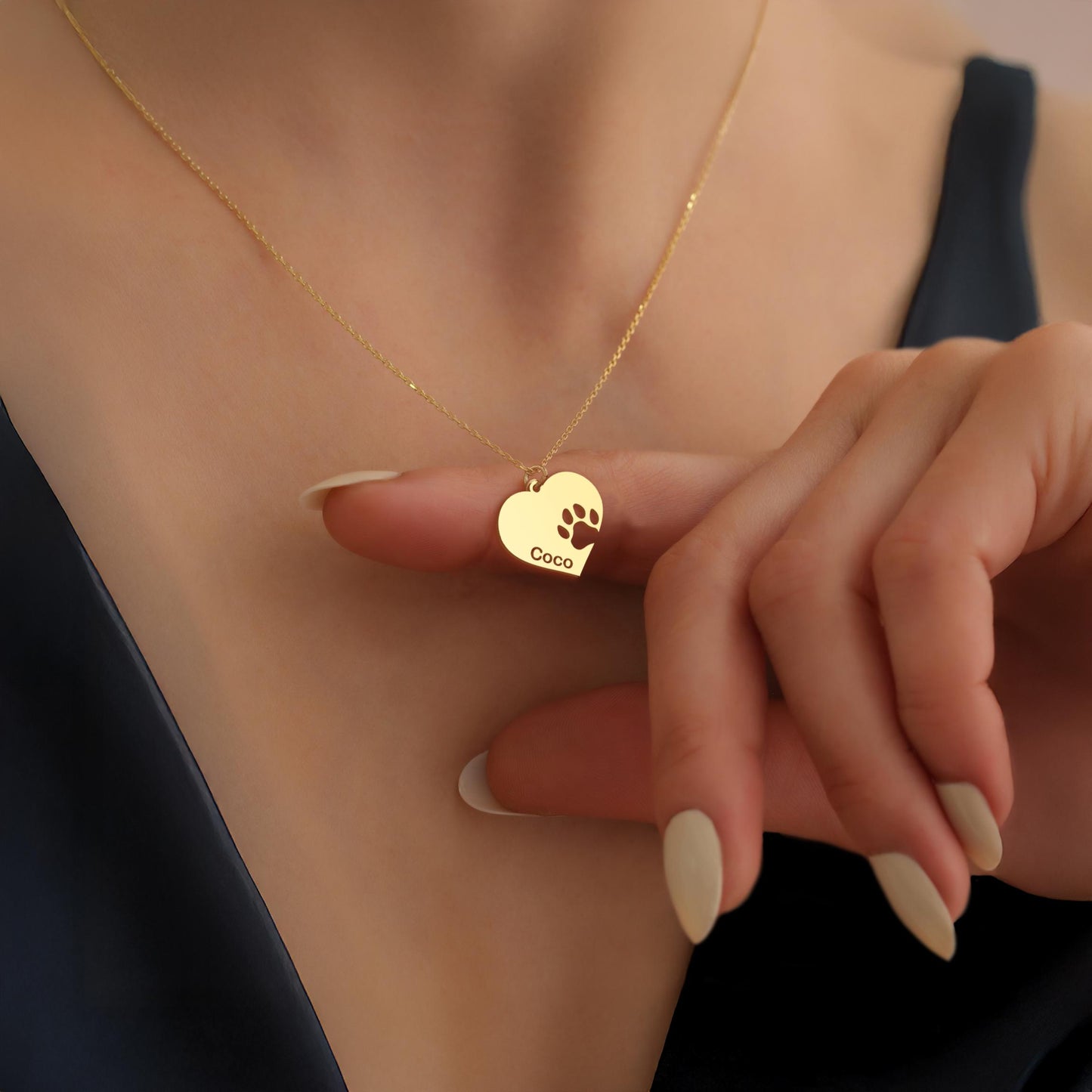 May include: A gold heart-shaped pendant necklace with a paw print cutout and the name 'Coco' engraved on it.